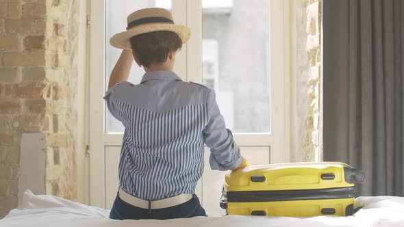 Gorgeous Elegant Caucasian Woman Taking Yellow Travel Bag and Leaving Hotel Room or Bedroom. Smiling