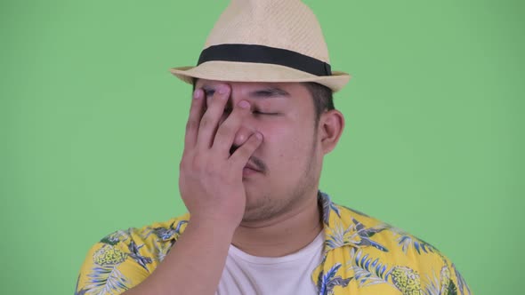 Face of Stressed Young Overweight Asian Tourist Man Showing Face Palm Gesture