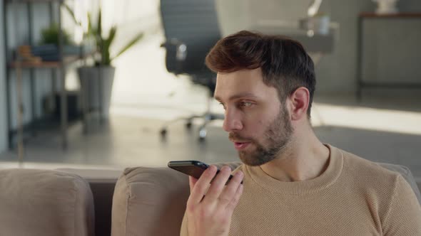 Young man recording an audio message on the phone