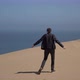 A Young Man Walks Along Sandy Dunes on the Seashore - VideoHive Item for Sale