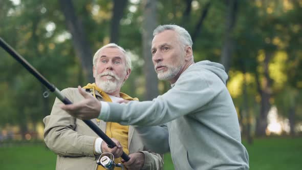 Two Pensioners Catching Big Fish, Pulling Spinning Together, Friendship Support