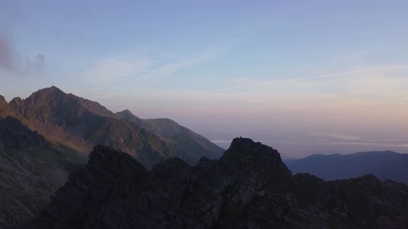 Stunning sunset sky over rugged terrain of remote Romania. Jagged mountain peaks and steep cliffs wi