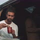 Young man enjoying food sitting in the back of a van - VideoHive Item for Sale