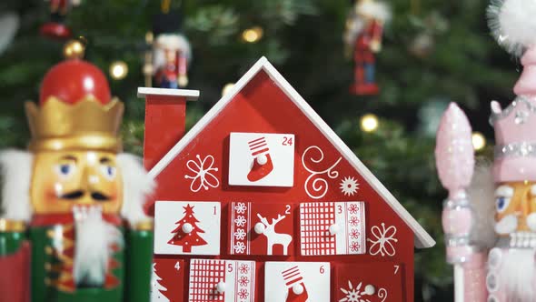 Wooden Tree Advent Calendar in Front of a Real Christmas Tree Decorated Nutcracker Soldier Toys.