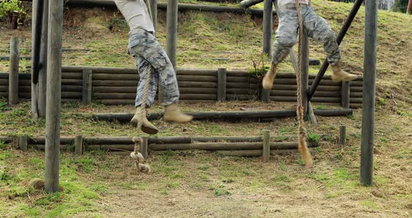 Military soldier climbing rope during obstacle course