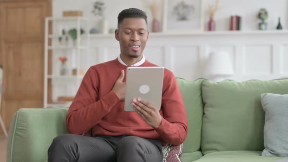 African Man Talking on Video Call on Tablet on Sofa