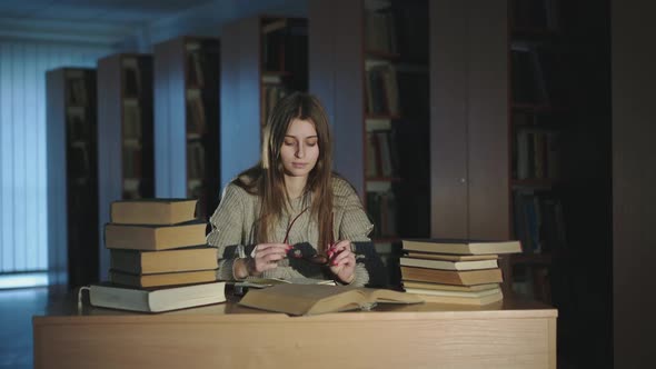 Cute Girl Putting on Glasses and Thinking During Noting Compendium at the Desk