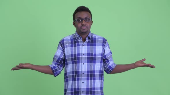 Confused Young African Hipster Man Shrugging Shoulders