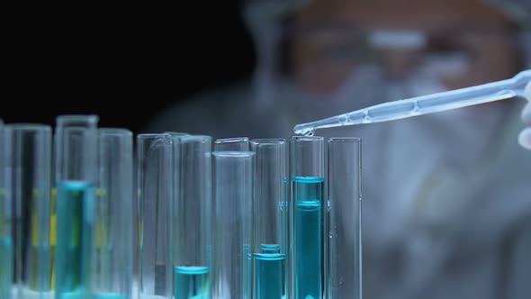 Researcher Dripping Chemical Liquid Into Tube, Analyzing Substance Properties