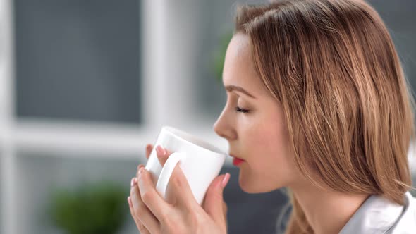 Close Up Face of Pretty Girl Drink Hot Beverage From Cup Feeling Satisfied