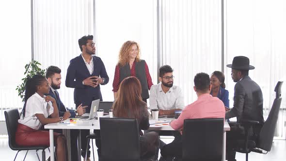 Group of Mixed-race Diverse Co-workers Discussing New Project in Office