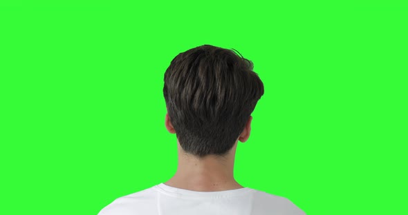 Head Shot of Man On Green Screen. Male model Watching Tv. Shot behind model shoulders.