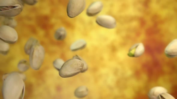 Closeup of Salted Pistachios Flying Diagonally on a Yellow Ochre Background