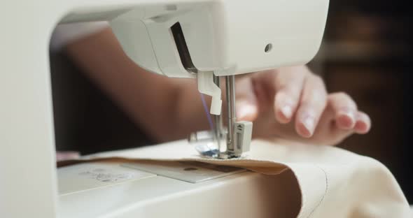 Woman Dressmaker Tailoring Using Industrial Sewing Machine Closeup