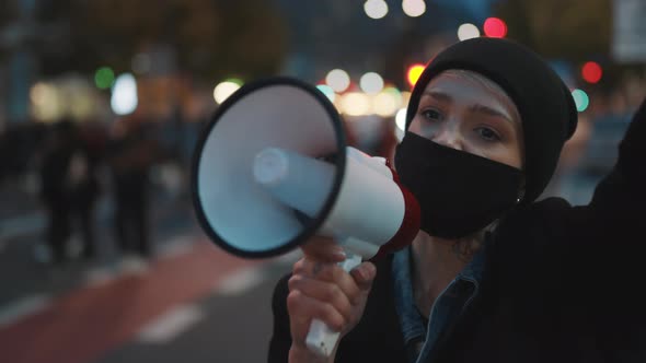 Demonstrations Against Covid-19 Lockdown Measures. Young Woman with Face Mask Shouting Into the