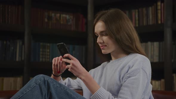 Close Up of a Caucasian Woman Browsing on Her Smart Phone Online in Doubt Thinking on a Decision