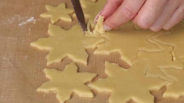 The Woman Cuts The Dough Into Pieces In The Form Of Snowflakes.