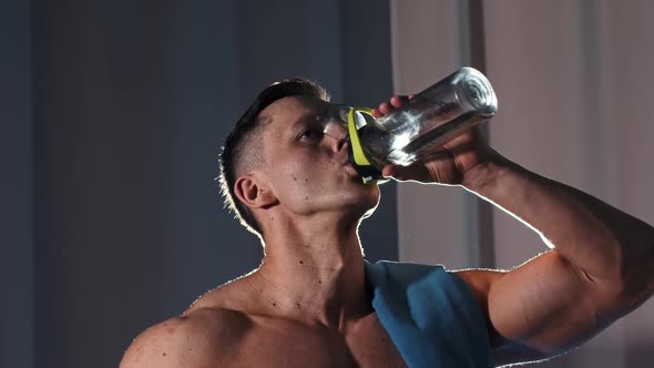 Athletic Muscular Shirtless Man Drinking Water From the Plastic Bottle
