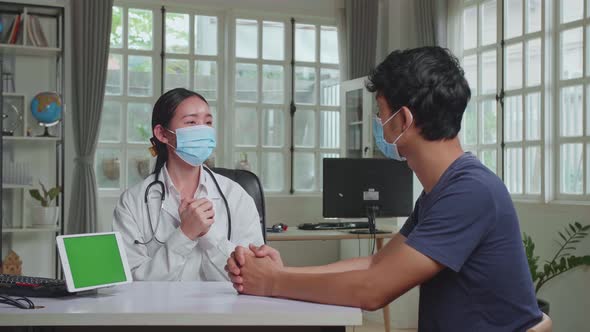 Asian Woman Doctor Showing Green Screen Display On Tablet Computer During Consultation