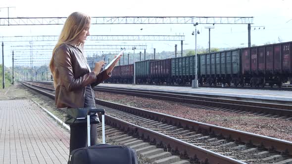 Woman Uses A Touch Panel On The Platform Waiting For A Train