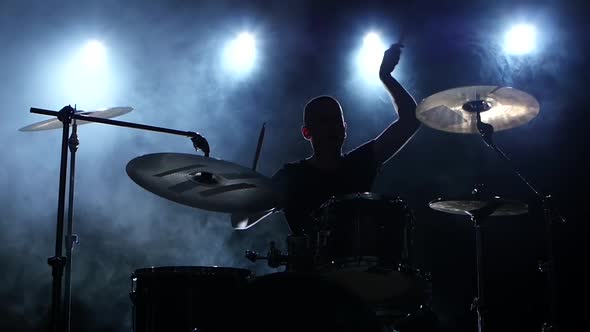 Energetic Music in the Performance of a Professional Drummer, Black Smoky Background, Silhouette