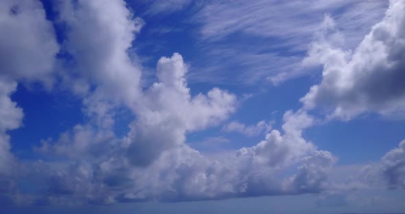 Natural flying travel shot of a paradise sunny white sand beach and blue water background in colorfu