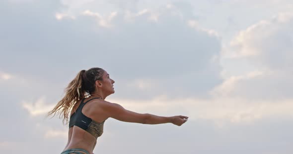 Slow motion of woman playing beach volleyball during sunset