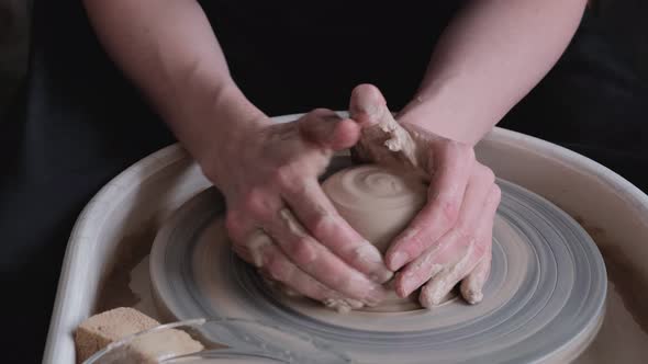 A woman works on a potter's wheel