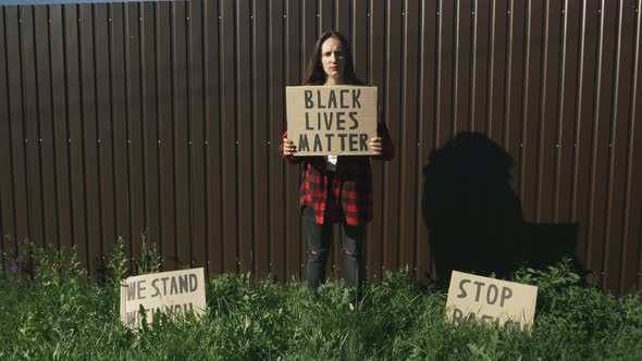 Poster "Black lives matter" in hands of caucasian woman. Stop Racism Rallies
