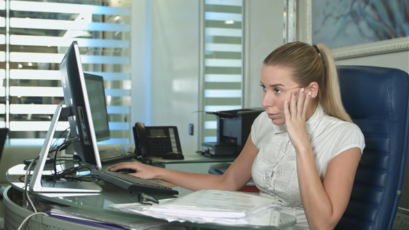 Portrait of young unhappy business woman at desk in office