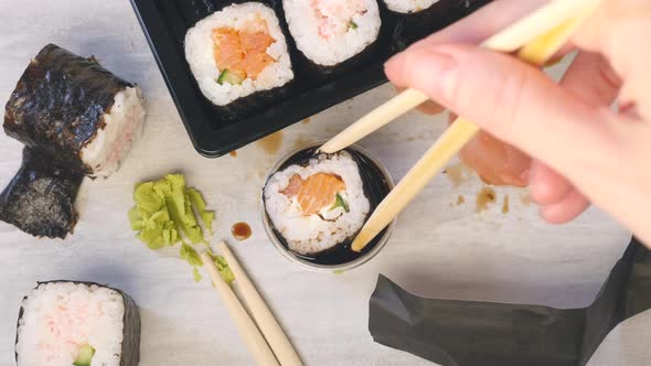 Hold Sushi with Chopsticks and Put Into Soy Sauce. Mess on the Table