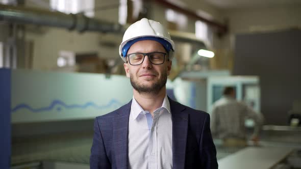 Portrait Young Male Manager of Furniture Factory in Suit and Helmet Monitoring Process of Work