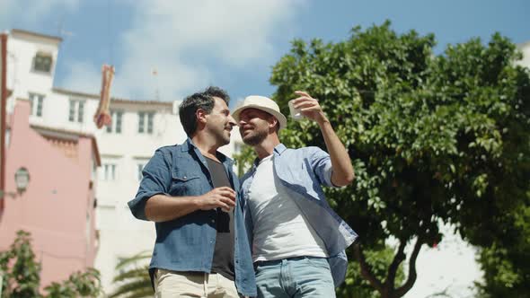 Medium Shot of Happy Gay Couple Standing in Street and Hugging