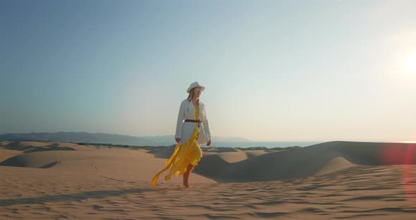 Romantic Woman Walking Alone in Desert at Sunset Hour