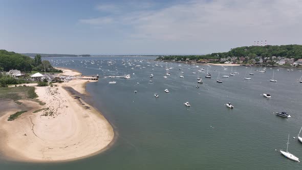 An aerial view over Northport Marina on Long island, NY with many anchored boats. It is a sunny day
