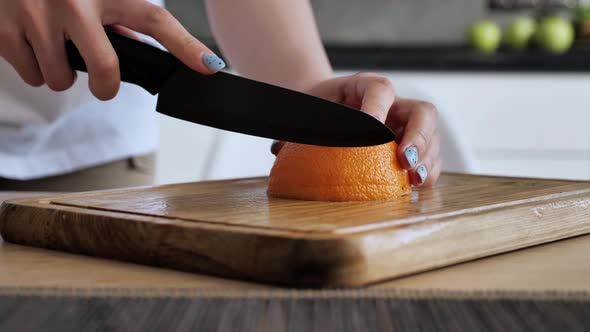 View of Cutting Orange with Knife Cutting Slice From Orange