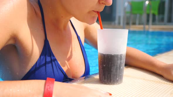 Sexy Girl Quenching Thirst with Cool Drink While Swimming in Hot Summer Day. Attractive Woman