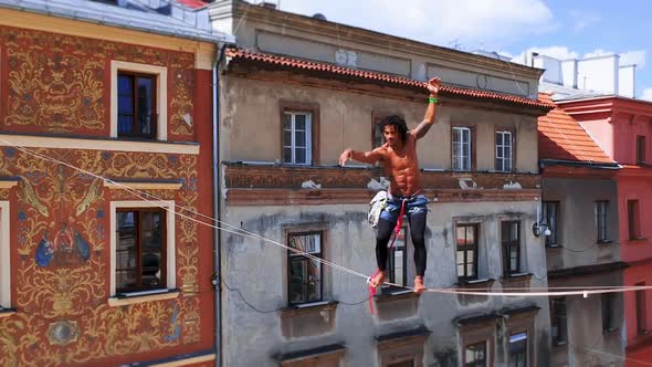 Man Balances on Tight Rope a View of the City From Height