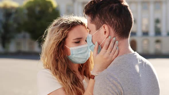 Young Family Couple in Love Medical Protective Masks in City Sunset