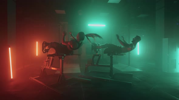 A Man and a Woman Do Abdominal Exercises Doing Body Lifts Together in the Gym