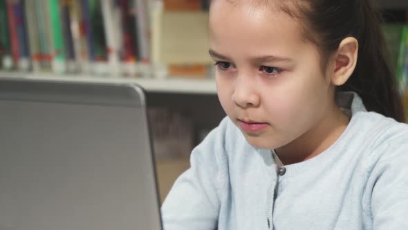 Cute Little Girl Concentrating Using Her Laptop