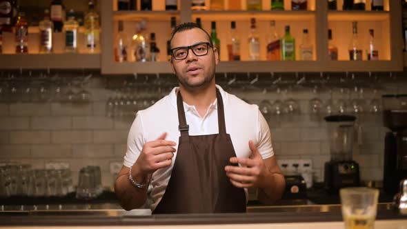 Smiling black bartender making a speech, greeting and talking