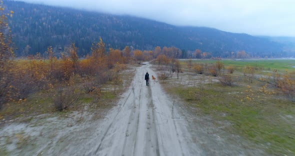 Man playing with his dog on dirt track 