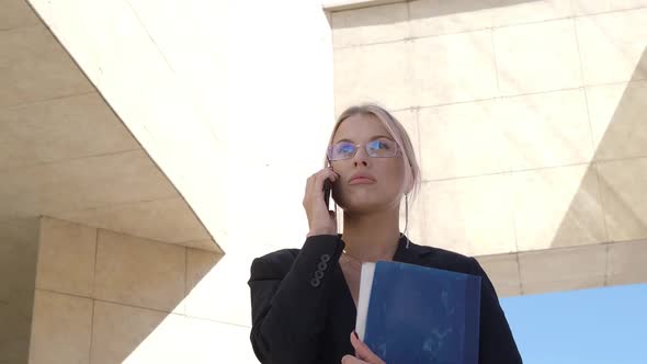 Serious Woman Lawyer Talking Phone While Walking in the Business District of the City.