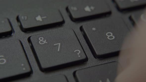 The Finger Presses a Button with a Number on the Keyboard