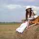 Pregnant Mom and Son Play Guitar and Sit on Haystack in the Field - VideoHive Item for Sale
