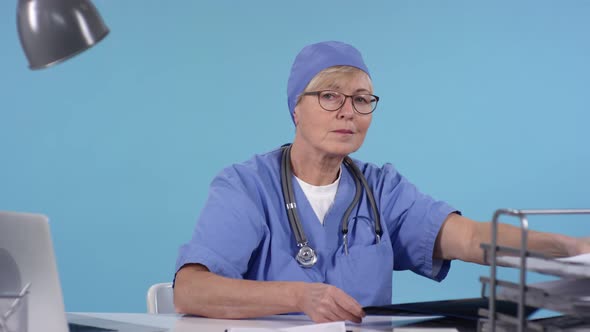 Middle-Aged Female Doctor Looking at X-Ray