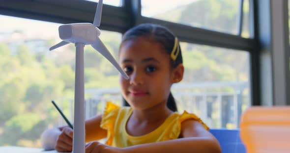 Mixed race schoolgirl studying at desk in classroom 4k