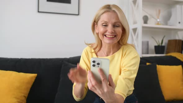 Hilarious Caucasian Woman Using Smartphone for Video Connection Staying at Home