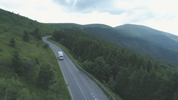 Drone Chasing White Cargo Van Driving on Forest Mountain Highway